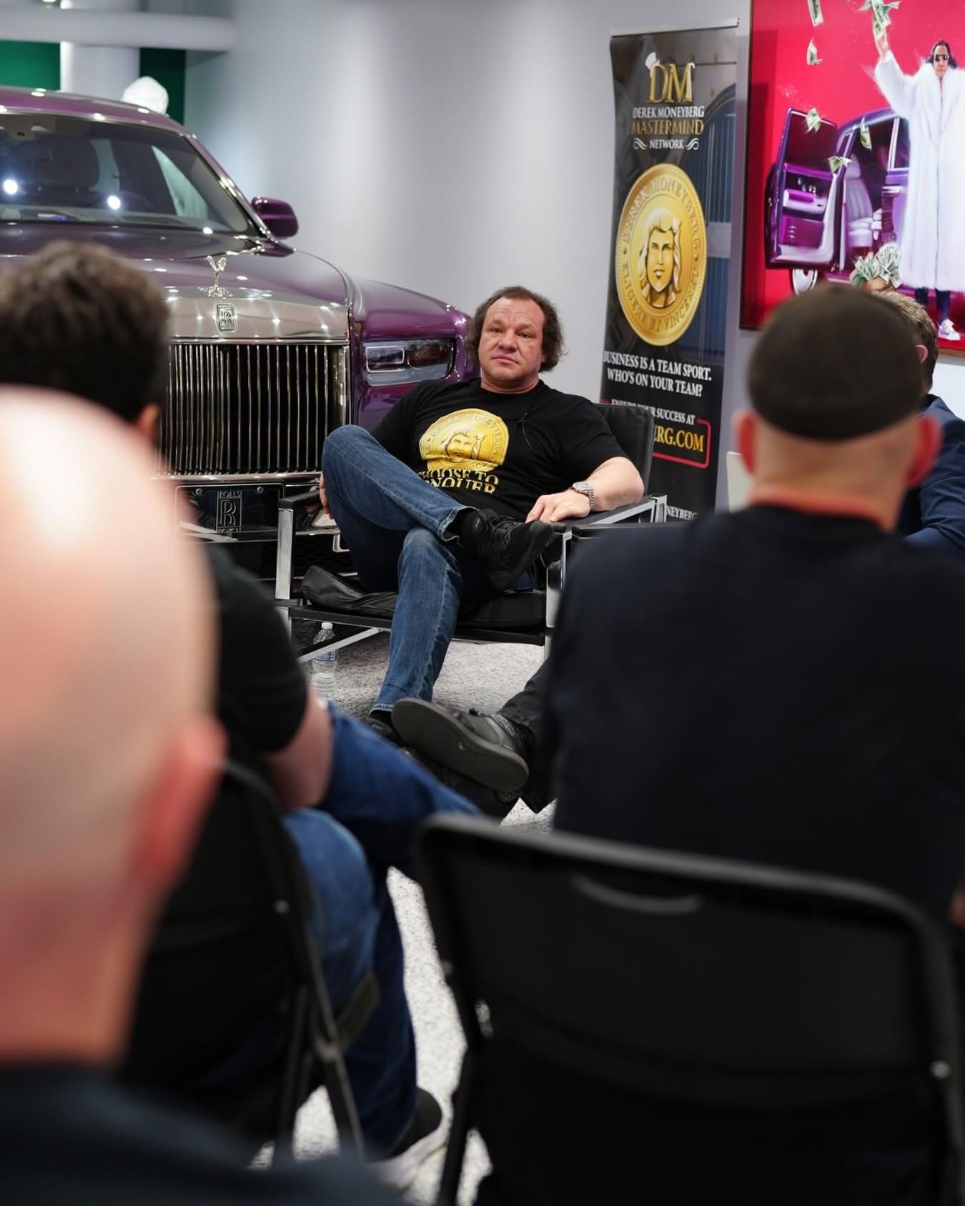 Derek Moneyberg seated in a group conversation